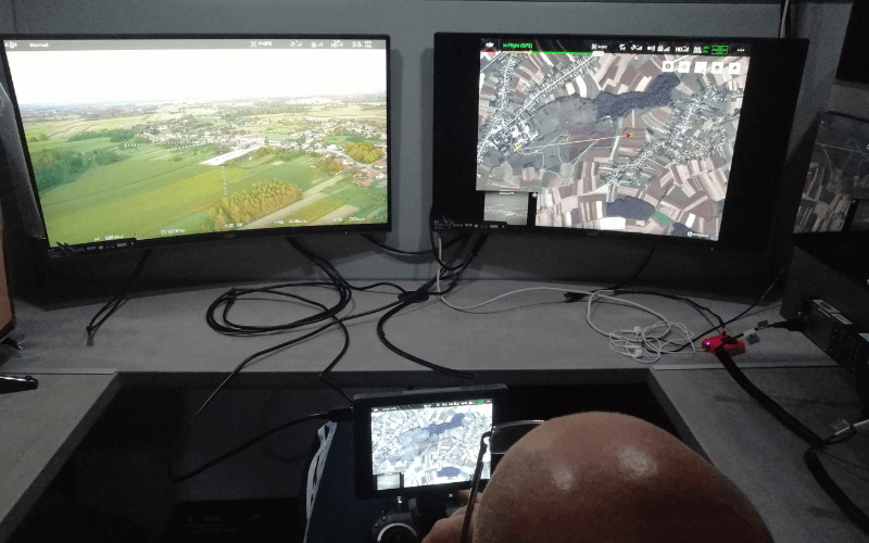 A man controlling a drone from the office - two monitors